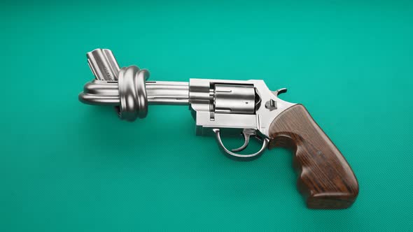 Revolver with a knot on the barrel. Metallic handgun laying on green fabric