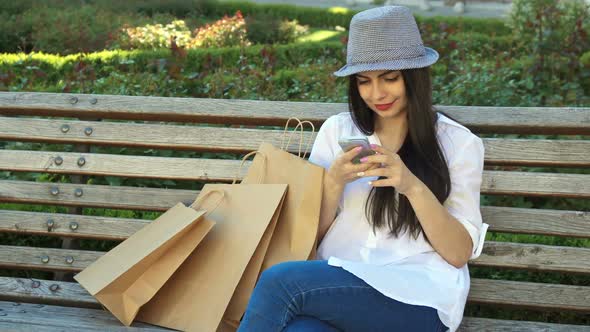 Girl Uses Her Smartphone on the Bench