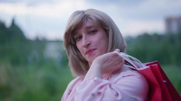 Closeup Portrait of Happy Transgender Woman Hanging Shopping Bags on Shoulder in Slow Motion Looking