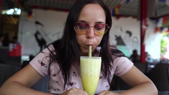 Woman drinking cocktail in cafe