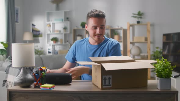 Young Man Unpacks a Parcel