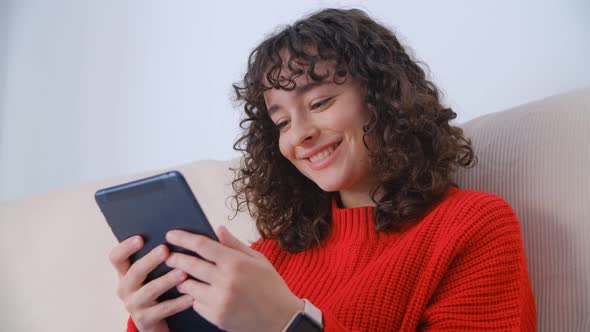 Beautiful brunette female browsing internet on tablet pc with cheerful smile in 4k video