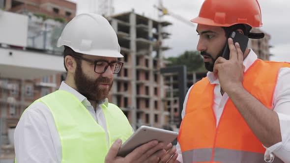 Engineer Speaks Mobile Phone Construction Site Checks Work Worker