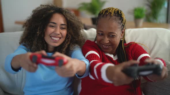 Happy mother and daughter having fun playing video game at home