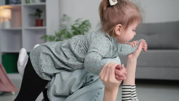 Happy Little Girl Has Fun with Mom While Playing the Plane Joyful Female Parent Kissing Her Child