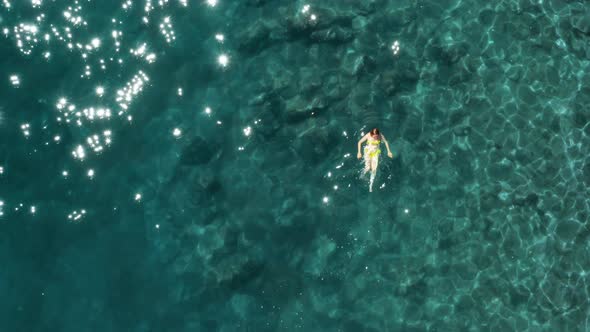 View Above a Woman Swimming in the Open Sea with Transparent Water