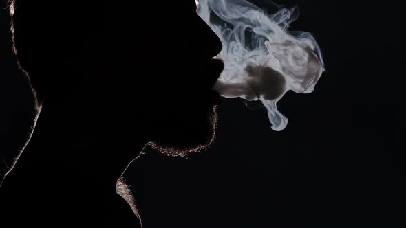 Man Smoking a E-cigarette and Coughing. Black. Silhouette. Close Up