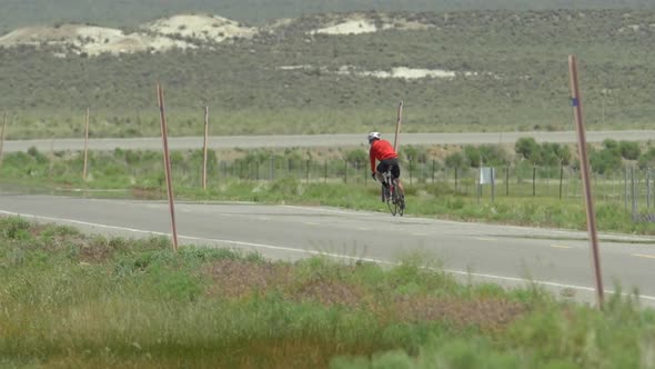 A man road biking on a scenic road.