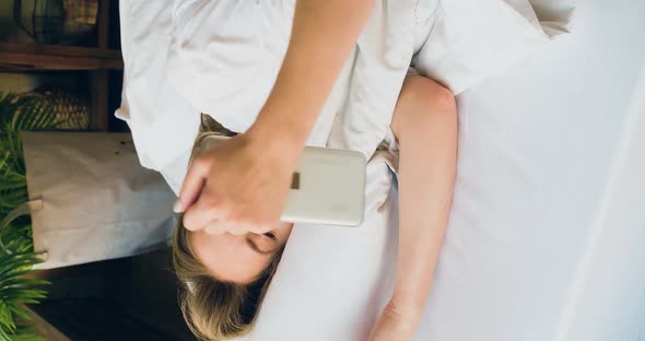 Closeup View of a Woman Waking Up Checking the Messages on Her Smartphone and Goes Back to Sleep