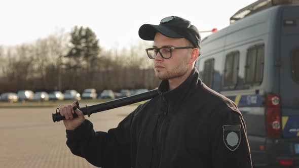 A Man in a Police Uniform is Turning His Head and Looking Seriously at the Camera