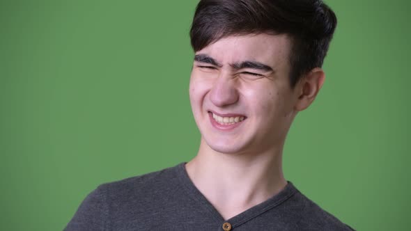 Young Handsome Iranian Teenage Boy Against Green Background