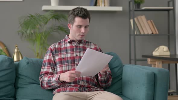 Man Celebrating Success on Laptop Sofa