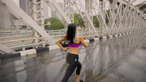 Middle-aged Asian woman jogging in the rain in Singapore 