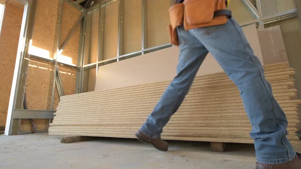 Construction Worker Moving Plywood Boards.