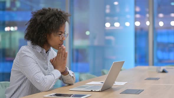 Pensive African Businesswoman Thinking and Working on Laptop in Office 