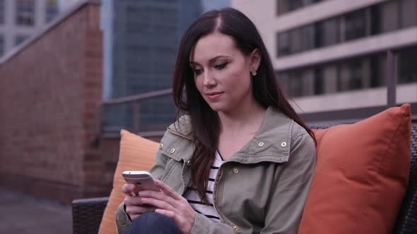 Woman on roof top using smartphone to make call.