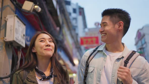 Asian active young couple travel in city for honeymoon trip at night.