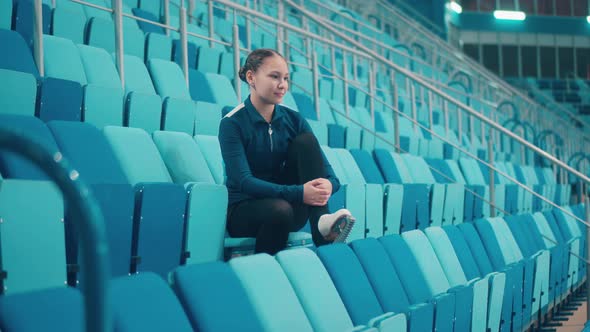 Sports Arena with a Young Female Skater on the Seats