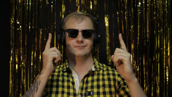 Portrait of Caucasian Man Dancing on Black Background. Gold Shining Foil Strips. Party, Music, Disco