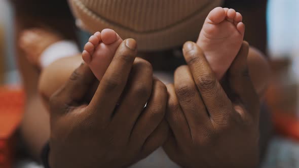 Black Father Playing with Baby Feet