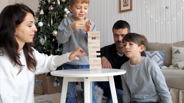 Family is Playing in Wooden Tower at Home