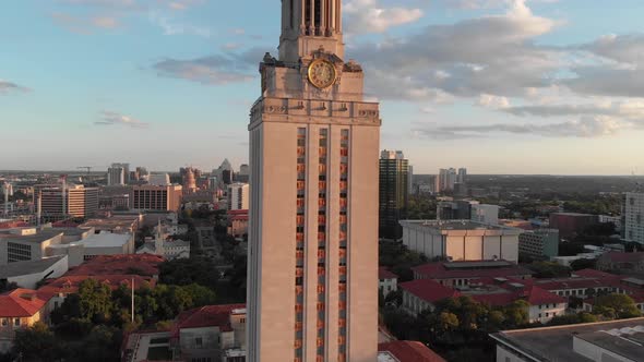 Slow drone shot of the UT tower with the hill country and downtown in the background.