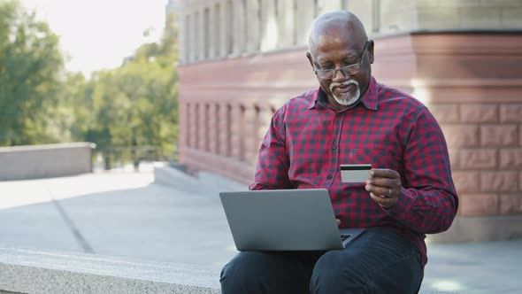 Happy Senior 60s Aged African American Customer Shopping Online Using Laptop