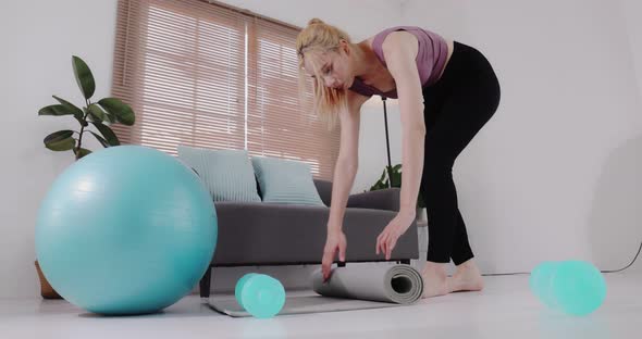 Young Asian beautiful fit sport woman rolling out yoga mat prepare to work out by exercise.