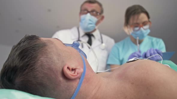 Doctors Examining a Patient on Bed in the Emergency Room of the Hospital