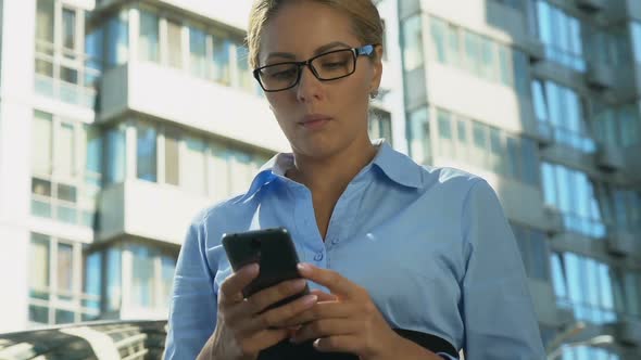 Frustrated Business Lady Reading Bad-News Message on Mobile Phone
