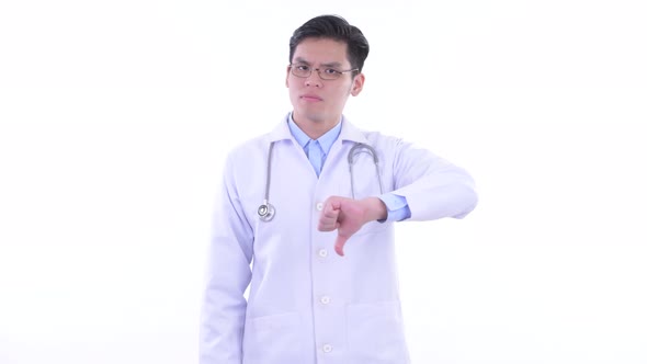 Stressed Young Asian Man Doctor Giving Thumbs Down