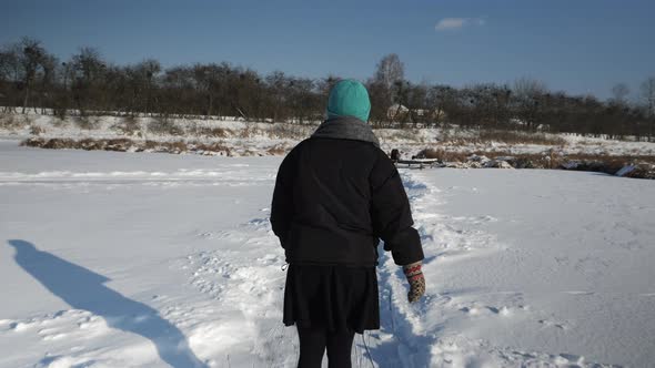 Tracking shot of woman ice skating on ice on river