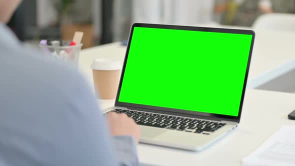 Rear View of African Woman Using Laptop with Green Chroma Key Screen