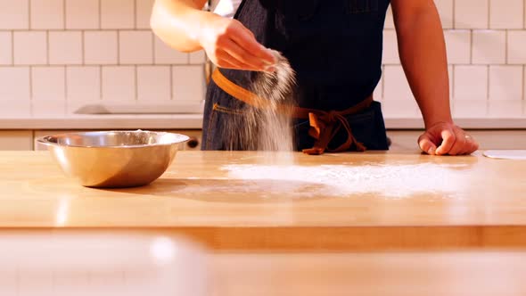 Chef spreading flour on the table