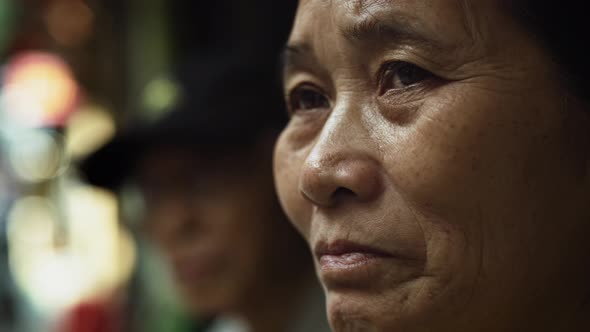 Handheld view of Vietnamese senior woman in the street. Shot with RED helium camera in 8K