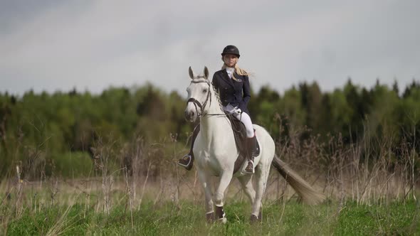 Training of Professional Female Jockey Woman is Wearing Riders Suit is Sitting on White Horse