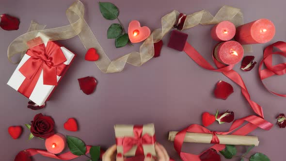 Hands are taking wrapped gift box with tied red bow for St. Valentine's Da