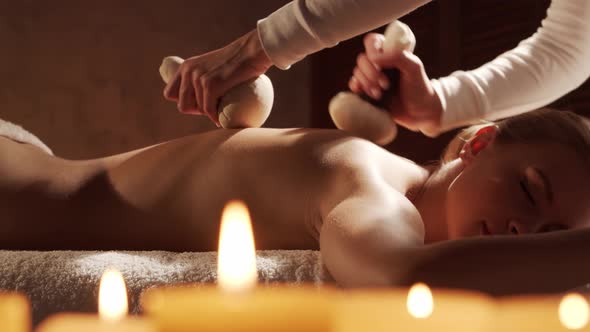 Young, healthy and beautiful woman gets massage therapy in the spa salon.