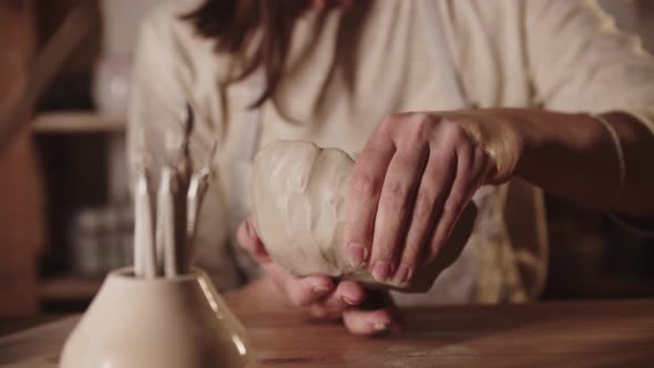 Young Woman Forming a Bowl Out of Soft Clay with Her Hands