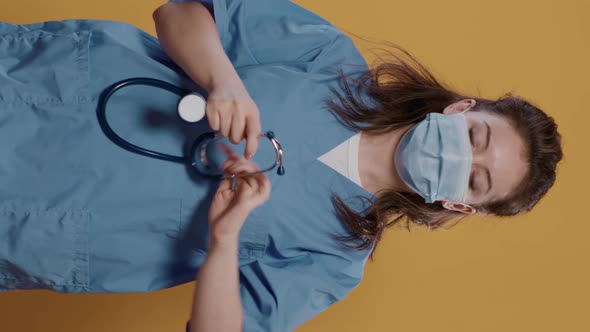 Portrait of Woman Medic Wearing Covid Mask for Protection Putting on Stethoscope and Showing It at