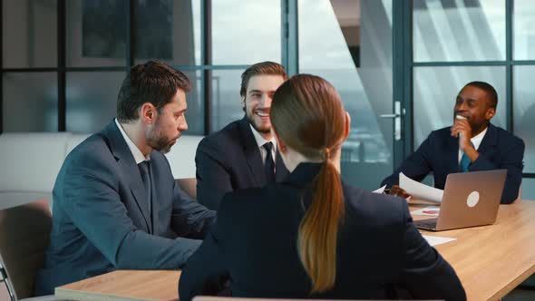 Group of people talking and working at the desk in the office