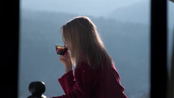 Young woman on balcony at chalet.