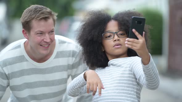 Young Cute African Girl with Afro Hair and Young Scandinavian Man Together in the Streets Outdoors