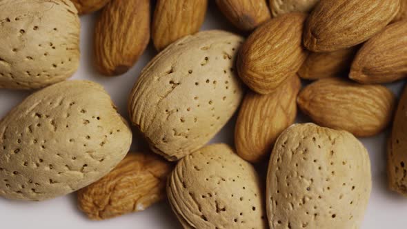 Cinematic, rotating shot of almonds on a white surface - ALMONDS