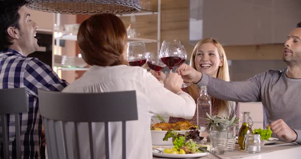 Four Friend Wearing Casual Cloth Chat Having Lunch Together in the Kitchen Eating Chicken and