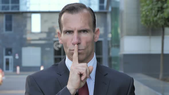 Silence Please, Finger on Lips by Beard Businessman