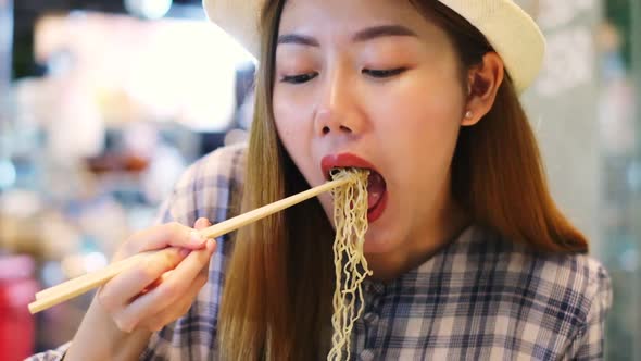 Asian Young woman  Eating Traditional Asian Street Food