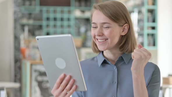 Portrait of Young Woman Celebrating Success on Tablet