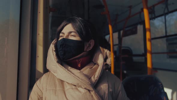 Young woman in protective mask in a city bus