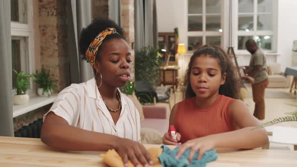 Mother And Daughter Doing Housework Together